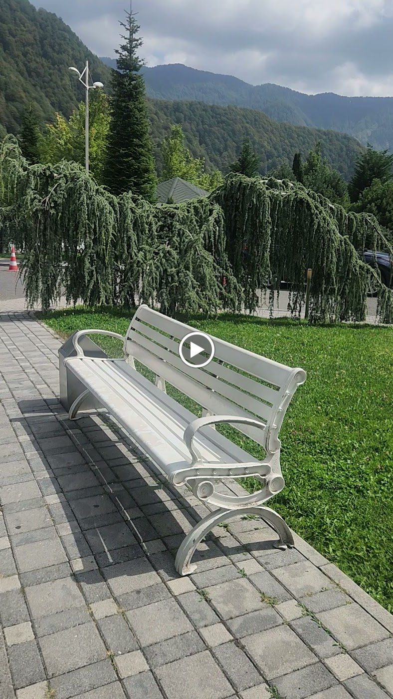 Зелёные горы и скамейка в парке курорта Туфандаг в Габале